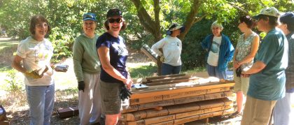 people smiling and constructing a railing